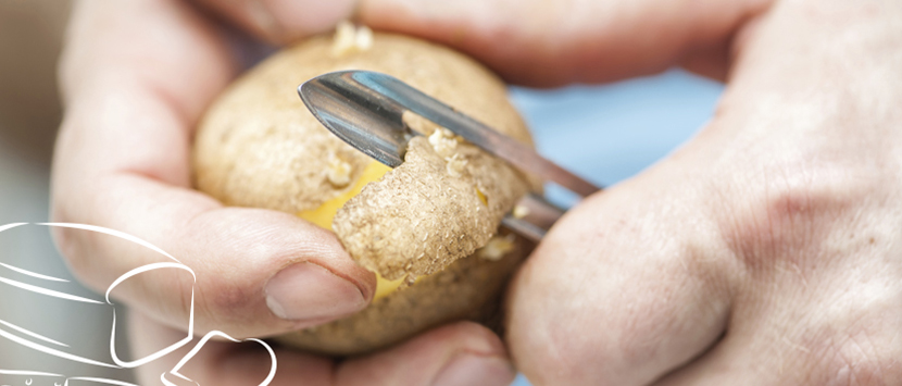 a close-up of a person peeling a potato