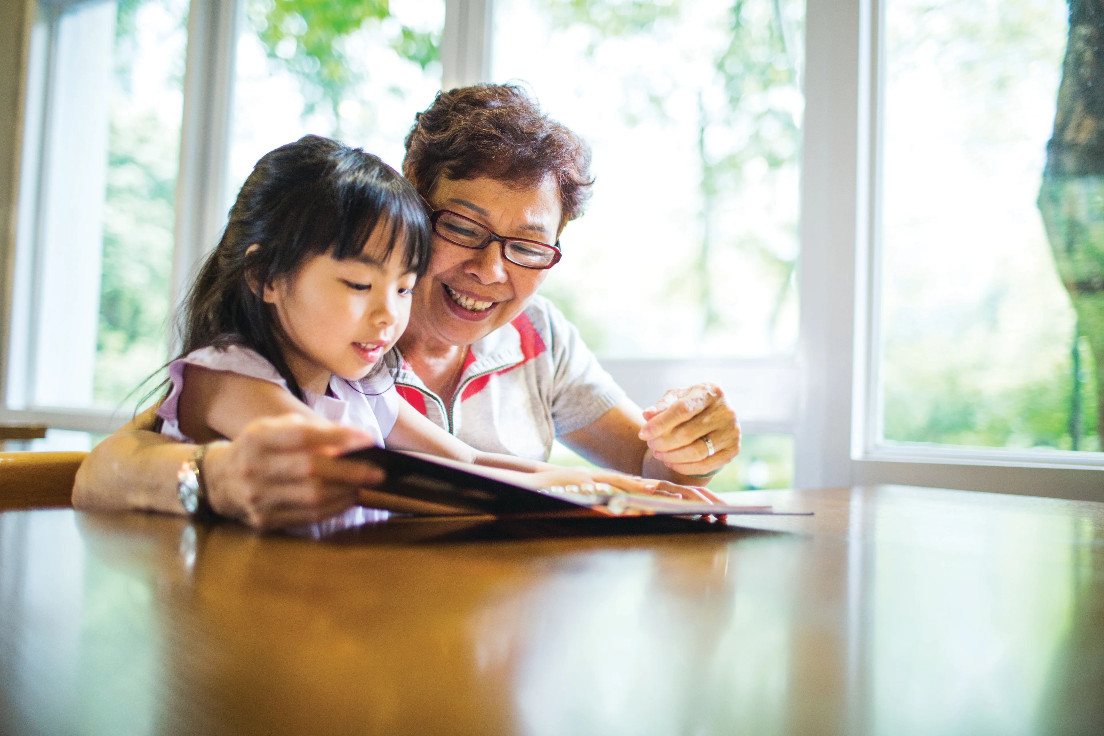 a woman and a girl reading a book