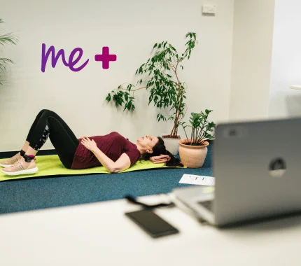 Člověk ležící na zemi vedle notebooku a rostliny