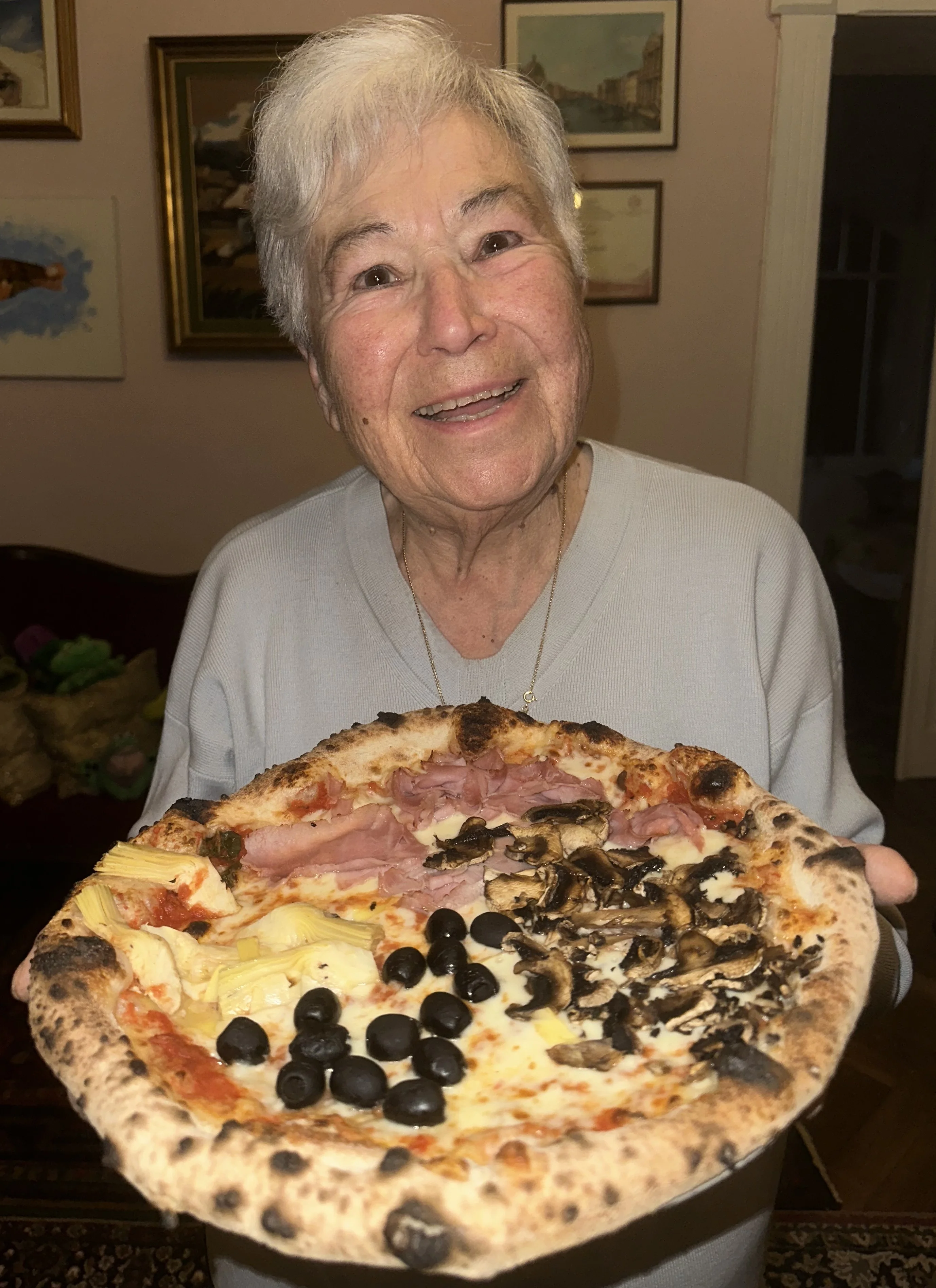 un uomo più anziano che tiene una pizza