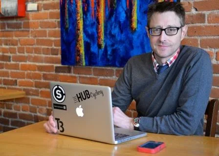 Obrázok muža žijúceho so stómiou, ktorý pózuje s notebookom