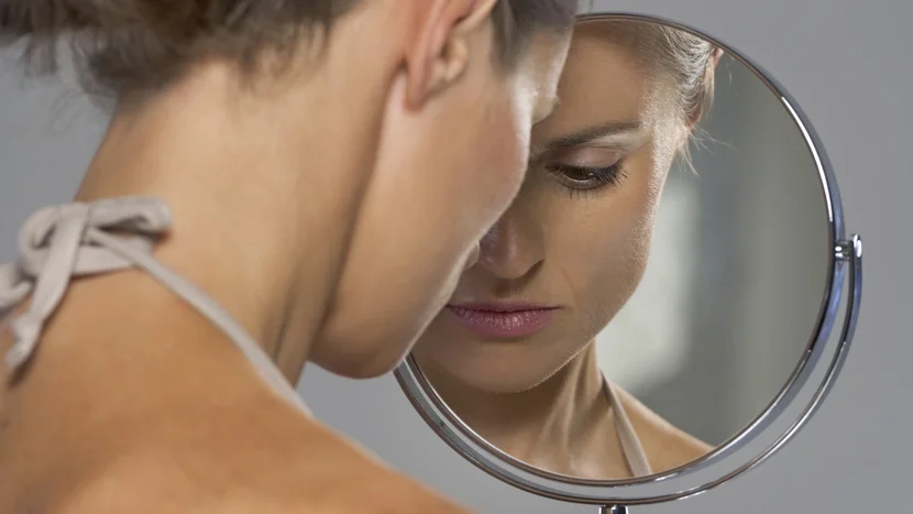a close-up of a woman looking into a mirror