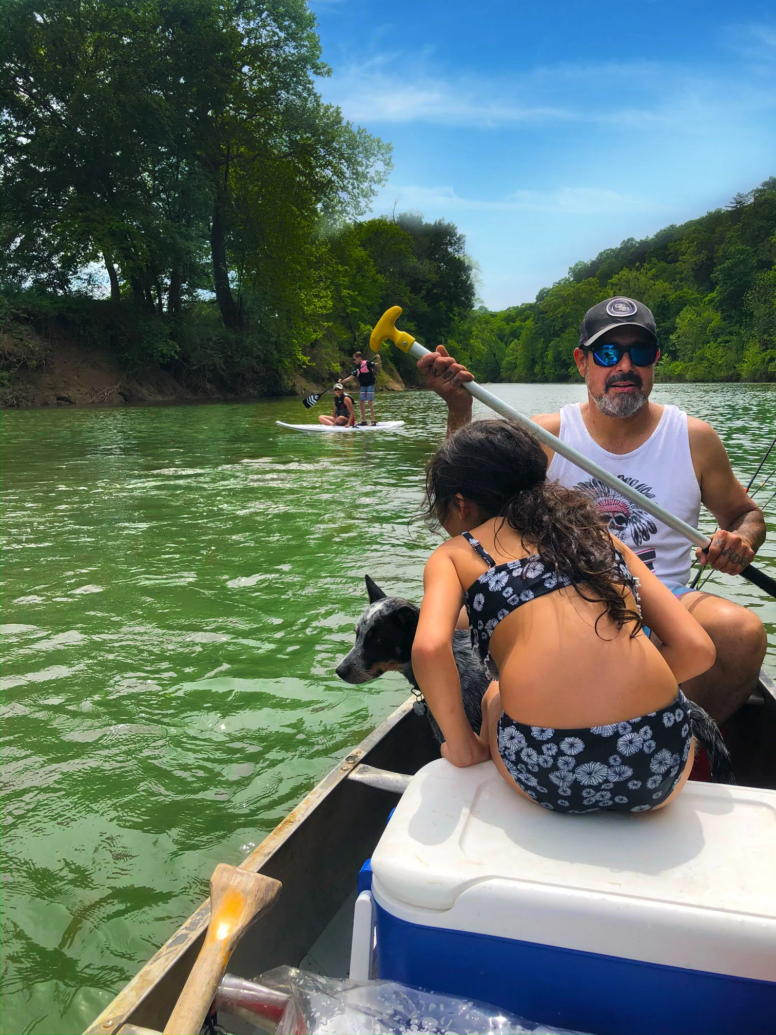 a man and a woman rowing a boat with a dog